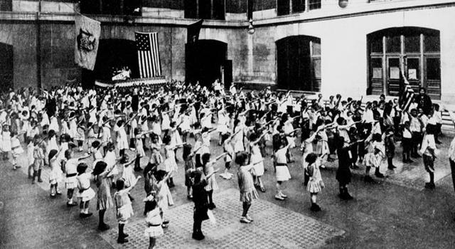 History Trivia Question: Why are the children in the photograph saluting the US Flag in that manner?
