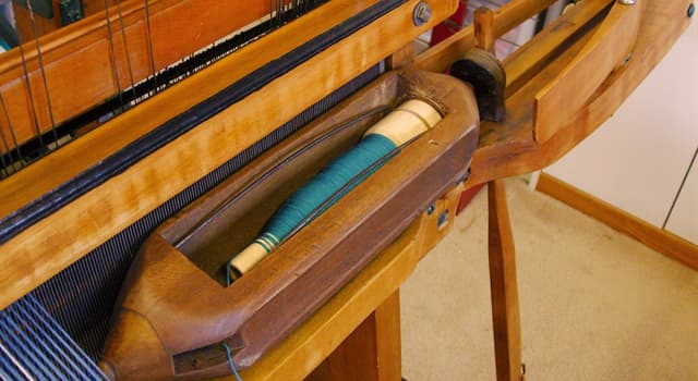 Society Trivia Question: What is a bobbin that carries the thread of the weft yarn while weaving with a loom called?