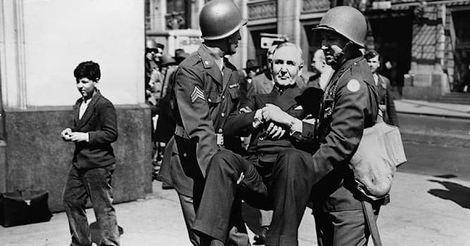 History Trivia Question: Who is the man being removed from his office, carried by the U.S. Army National Guard, in December 1944?